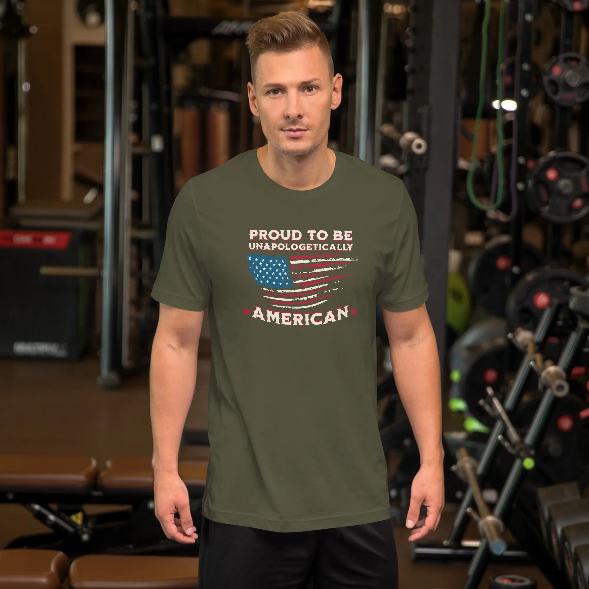 A man wearing a military green patriotic t-shirt with the american Flag and the text "Proud To be Unapologetically American"
