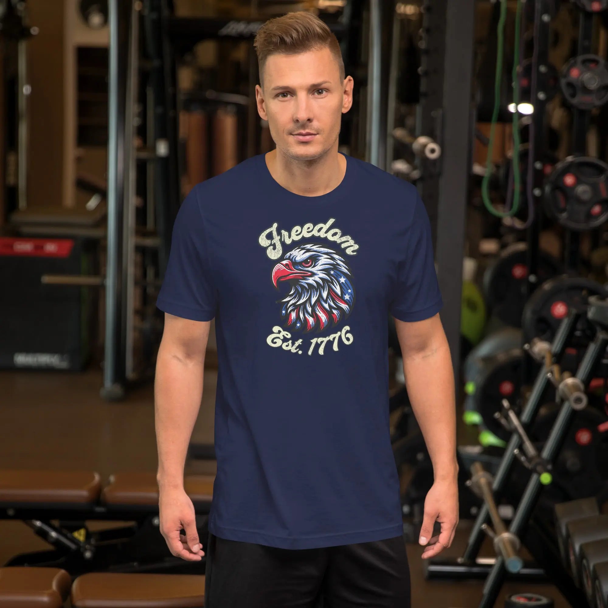 A man wearing a navy patriotic t-shirt with an eagle head with "Freedom Est. 1776" text.