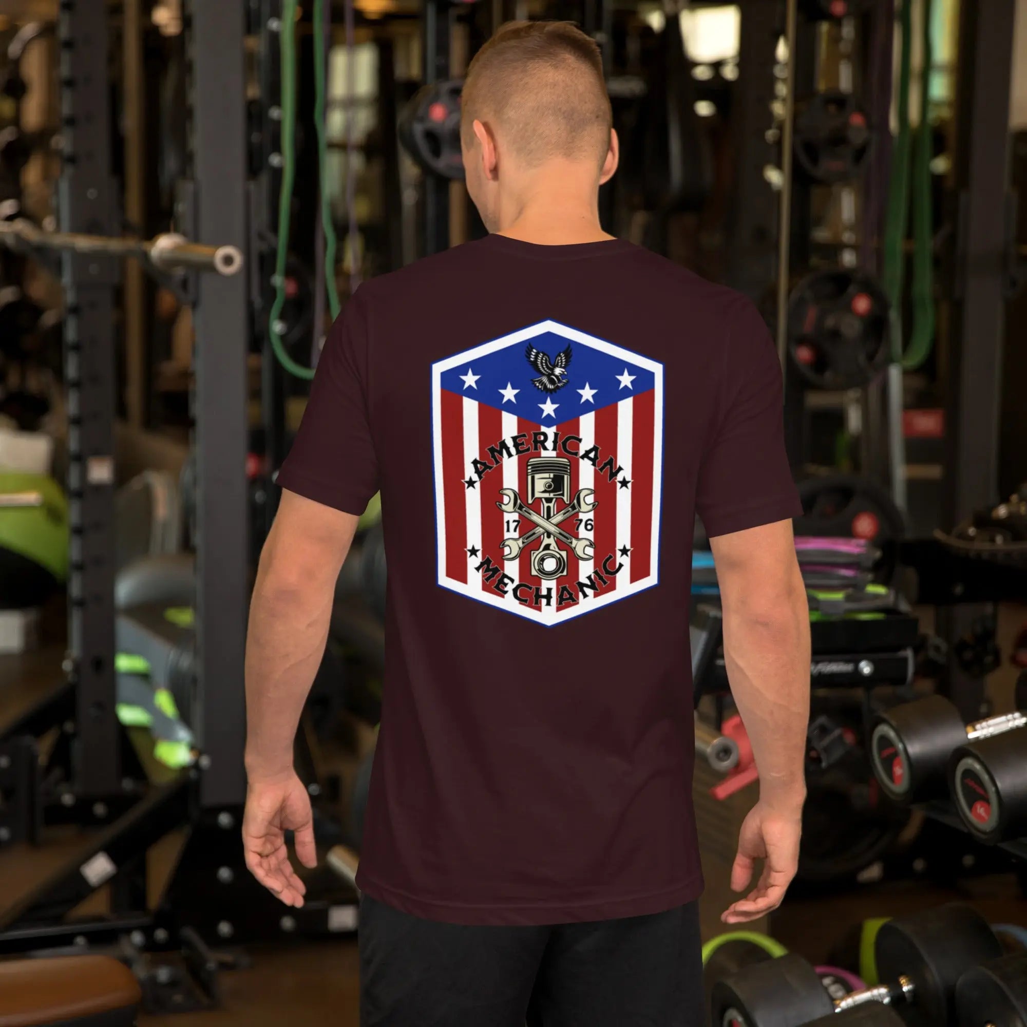 Back of man wearing a oxblood black  patriotic t-shirt with "American Mechanic" text
