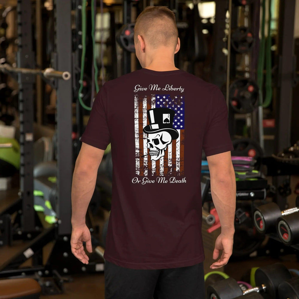 The back of a man wearing an oxblood black patriotic T-shirt with a skull over the American flag and the text "Give Me Liberty Or Give Me Death."