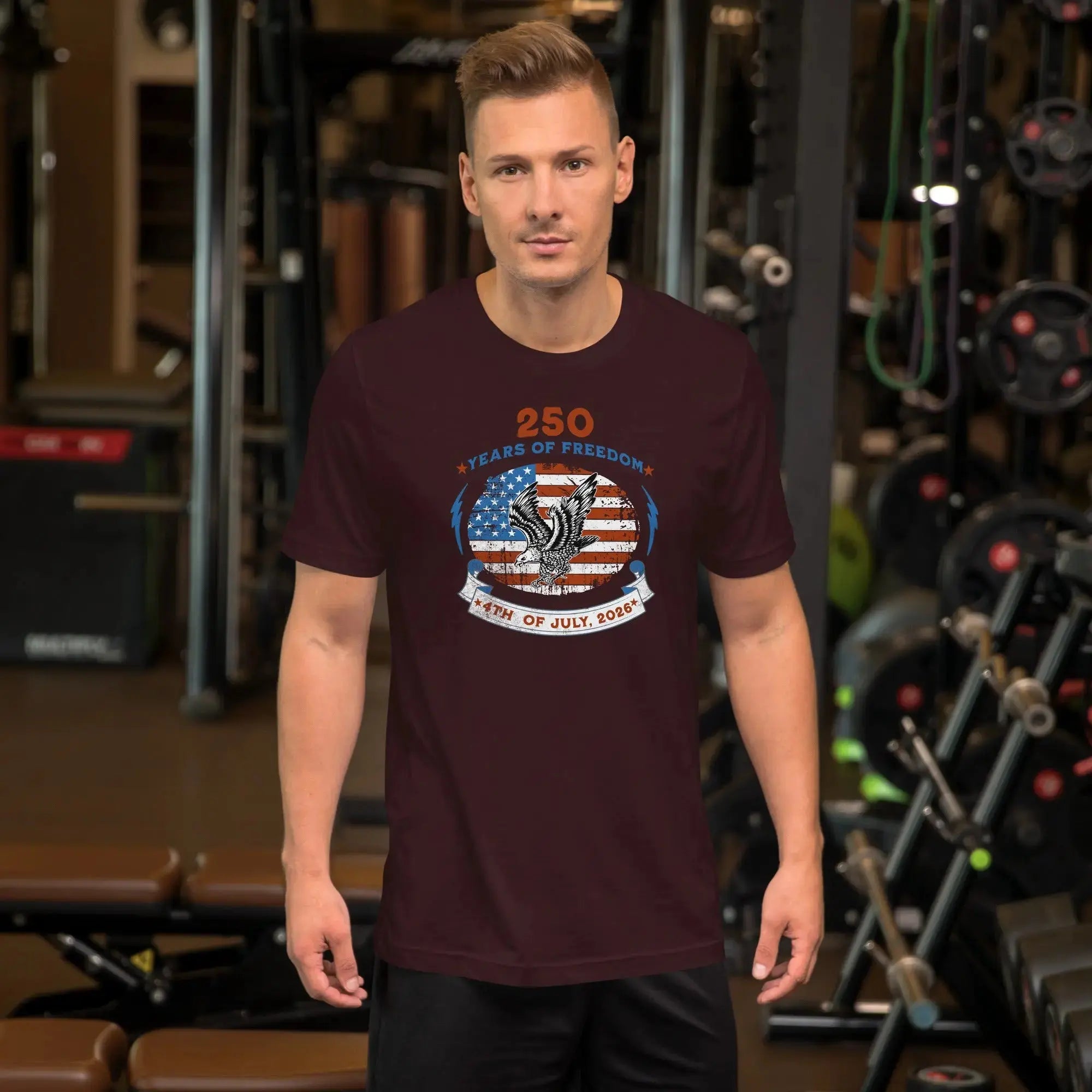 A man wearing an oxblood black patriotic men's t-shirt with an eagle over the American flag and the text "250 years of freedom, 4th of July, 2026."