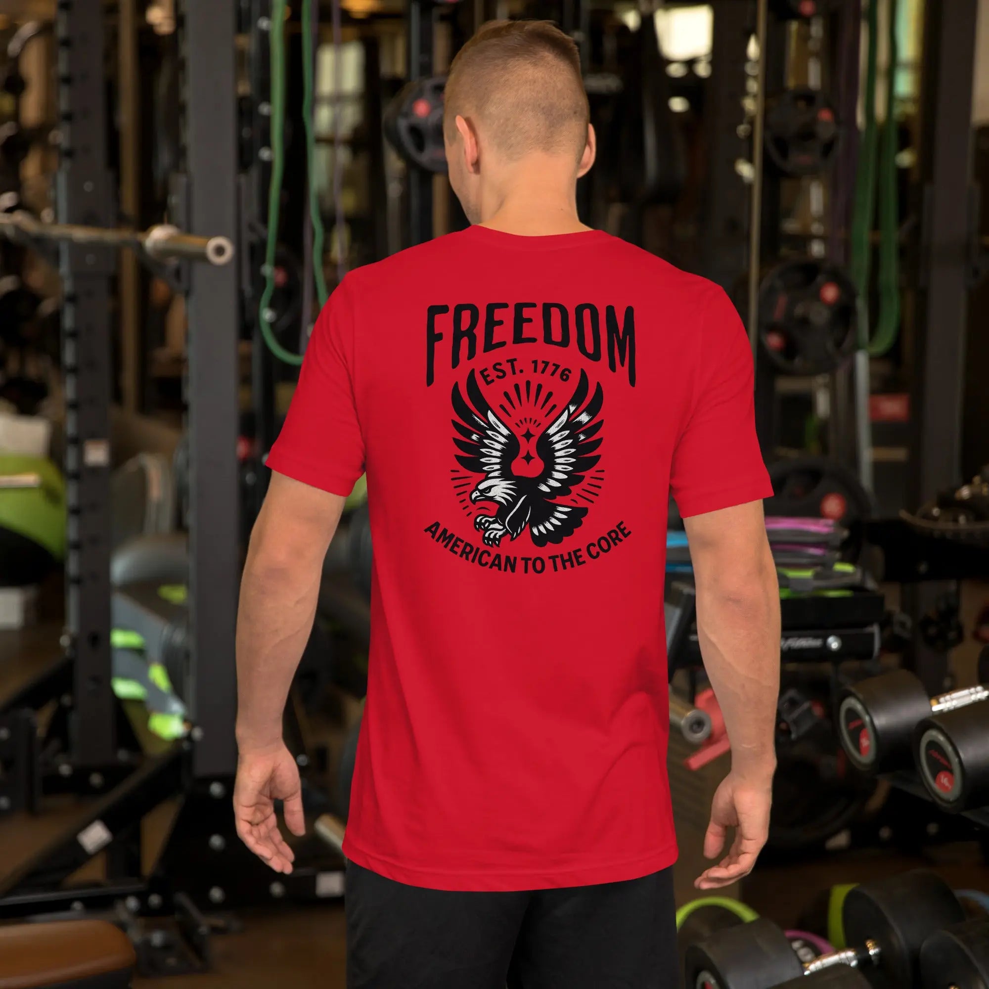 Back of man wearing a red patriotic t-shirt with an eagle and "freedom est. 1776" text