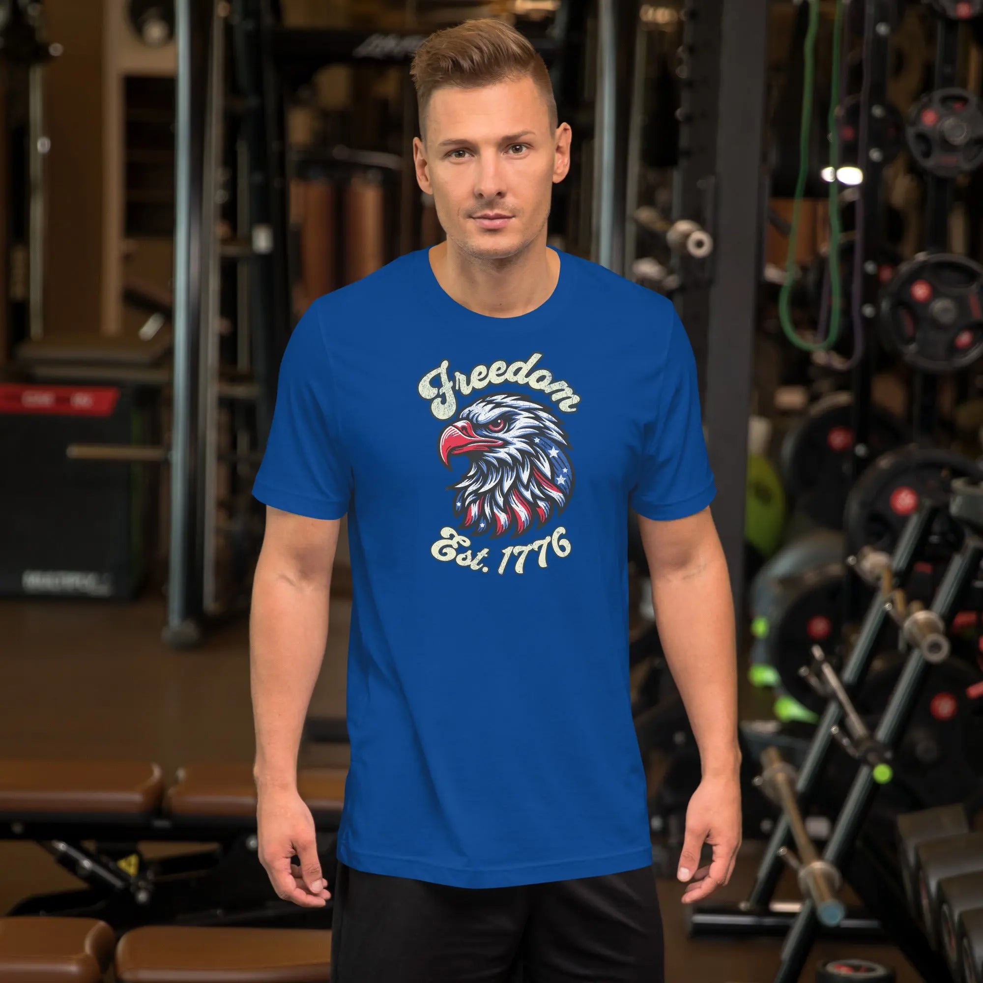A man wearing a royal blue patriotic t-shirt with an eagle head with "Freedom Est. 1776" text.