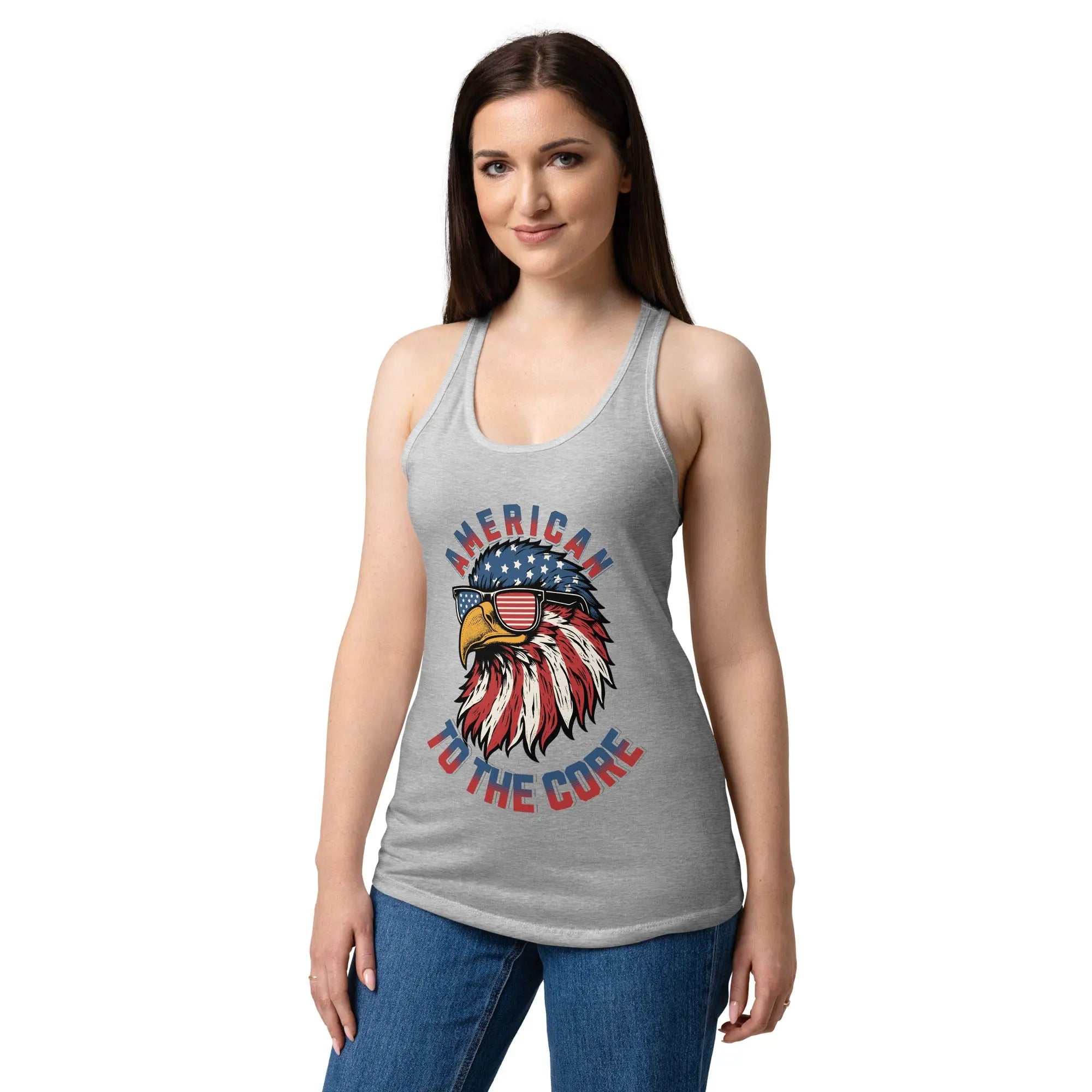 A woman wearing a heather grey patriotic tank top with a eagle head and the text "American to the core"