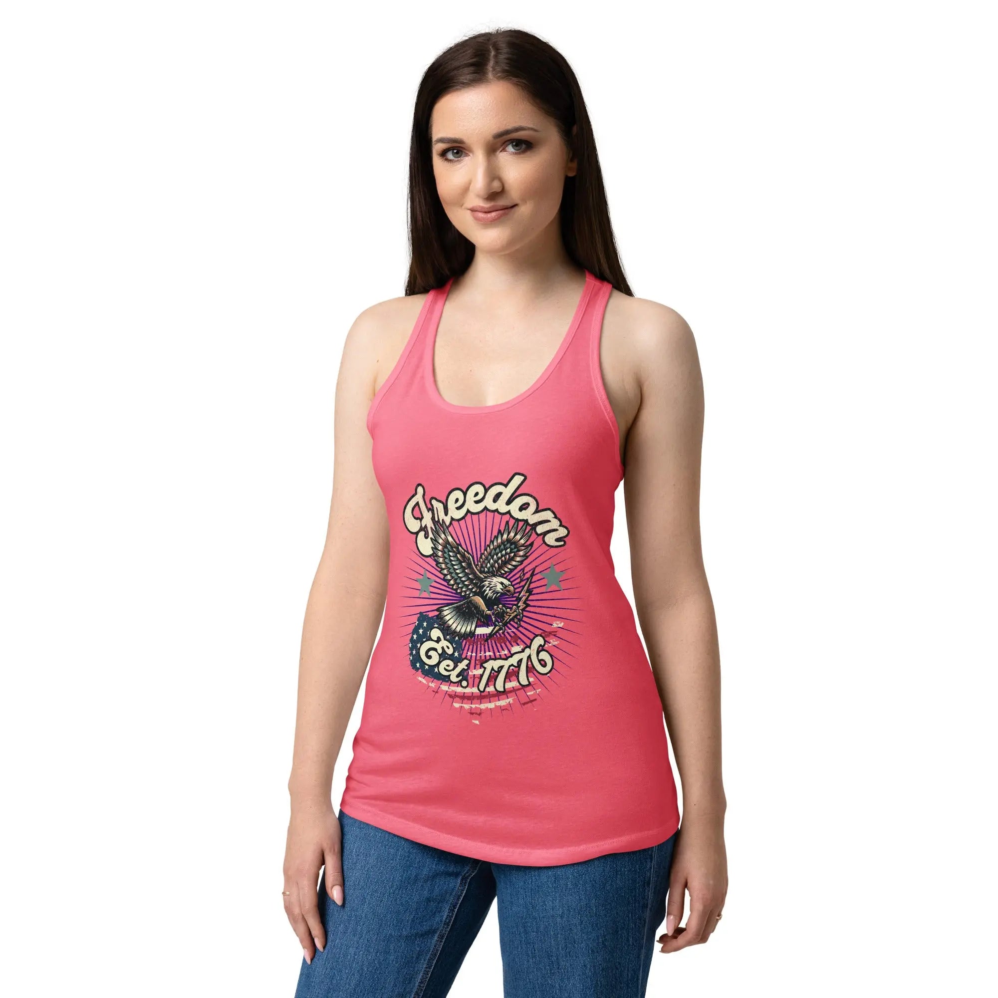 A woman wearing a hot pink, fitted, patriotic racerback tank top with a flying eagle and the text "Freedom est. 1776."