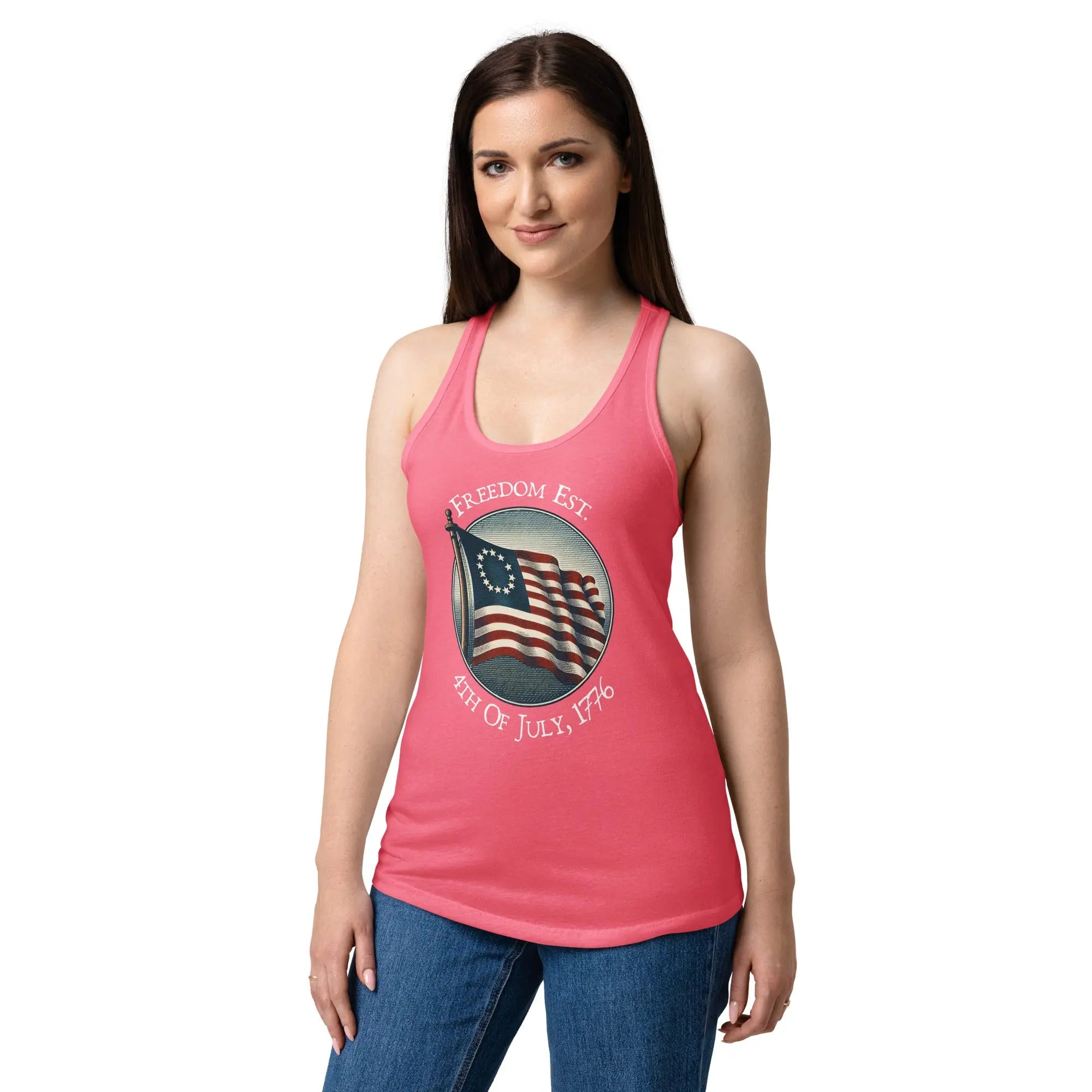 A woman wearing a hot pink patriotic racerback tank top with the American flag and the text "Freedom Est. 4th of July, 1776."