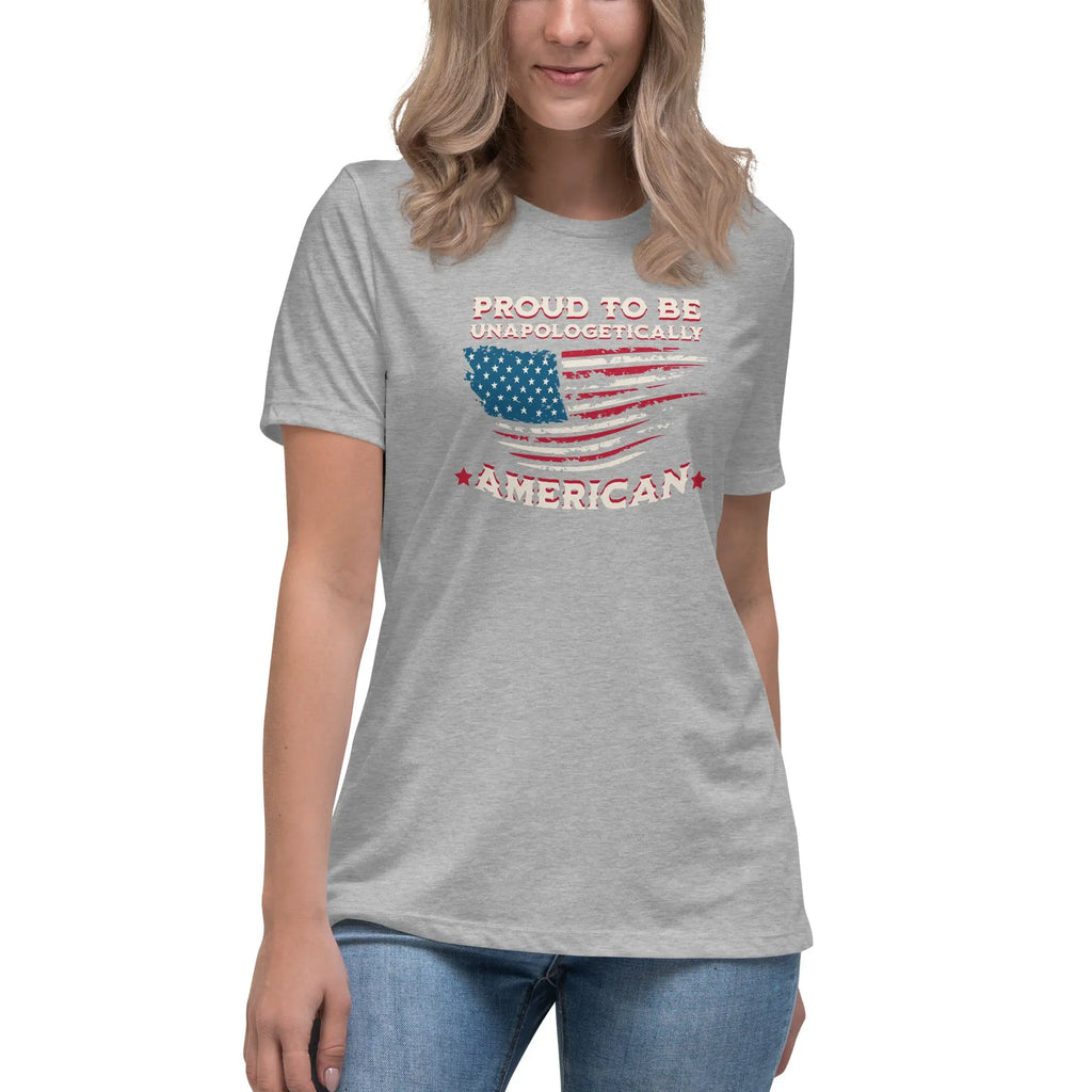 A woman wearing an athletic heather patriotic t-shirt with the American flag and "Proud To Be Unapologetically American" text.