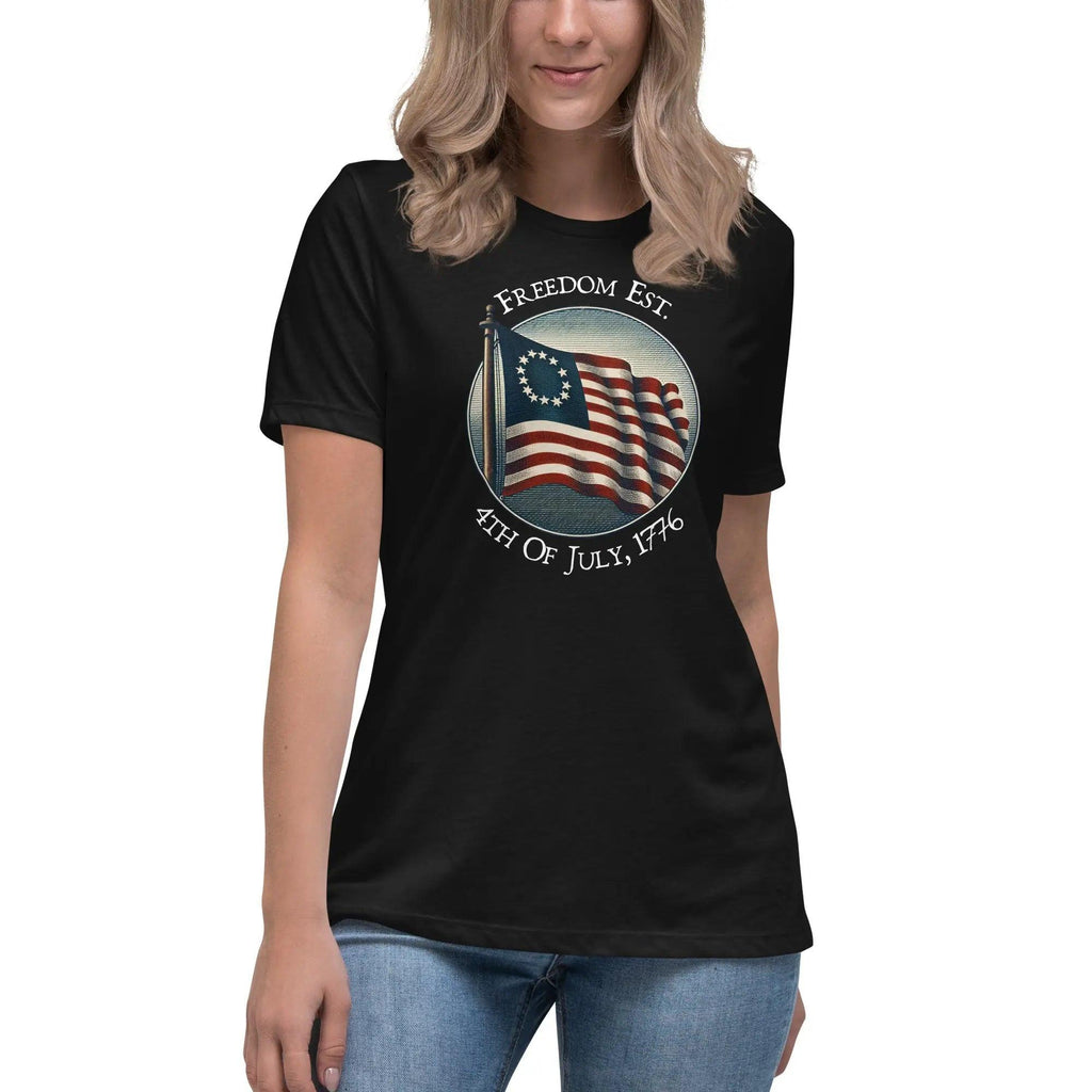 A woman wearing a black patriotic t-shirt with the American flag and the text "Freedom est. 4th of July, 1776."