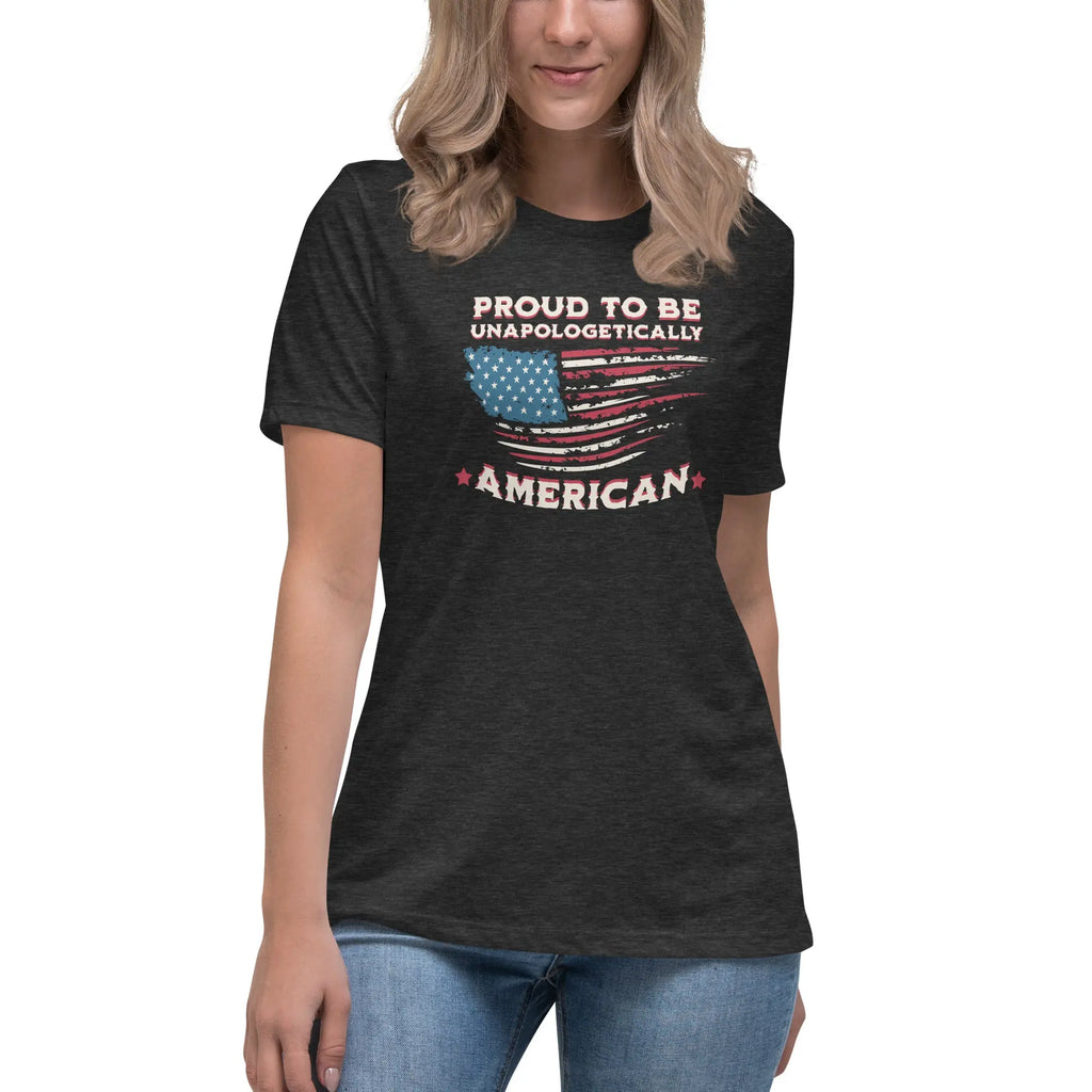 A woman wearing a dark grey heather patriotic t-shirt with the American flag and "Proud To Be Unapologetically American" text.