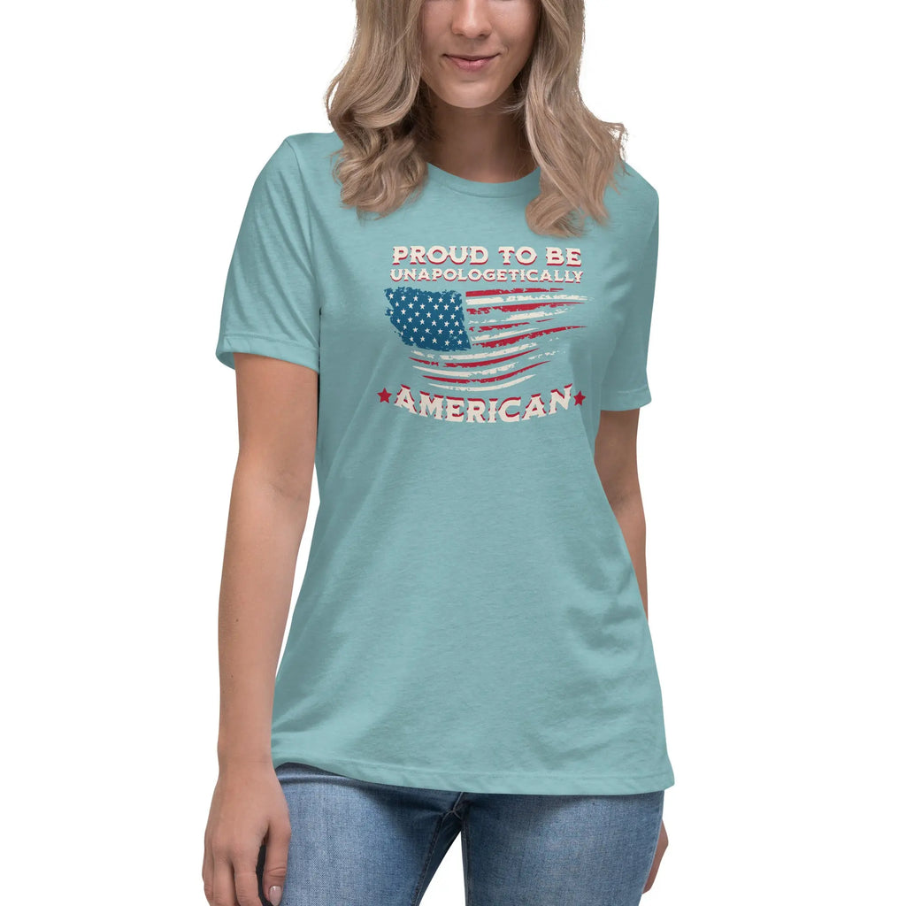 A woman wearing a heather blue lagoon patriotic t-shirt with the American flag and "Proud To Be Unapologetically American" text.