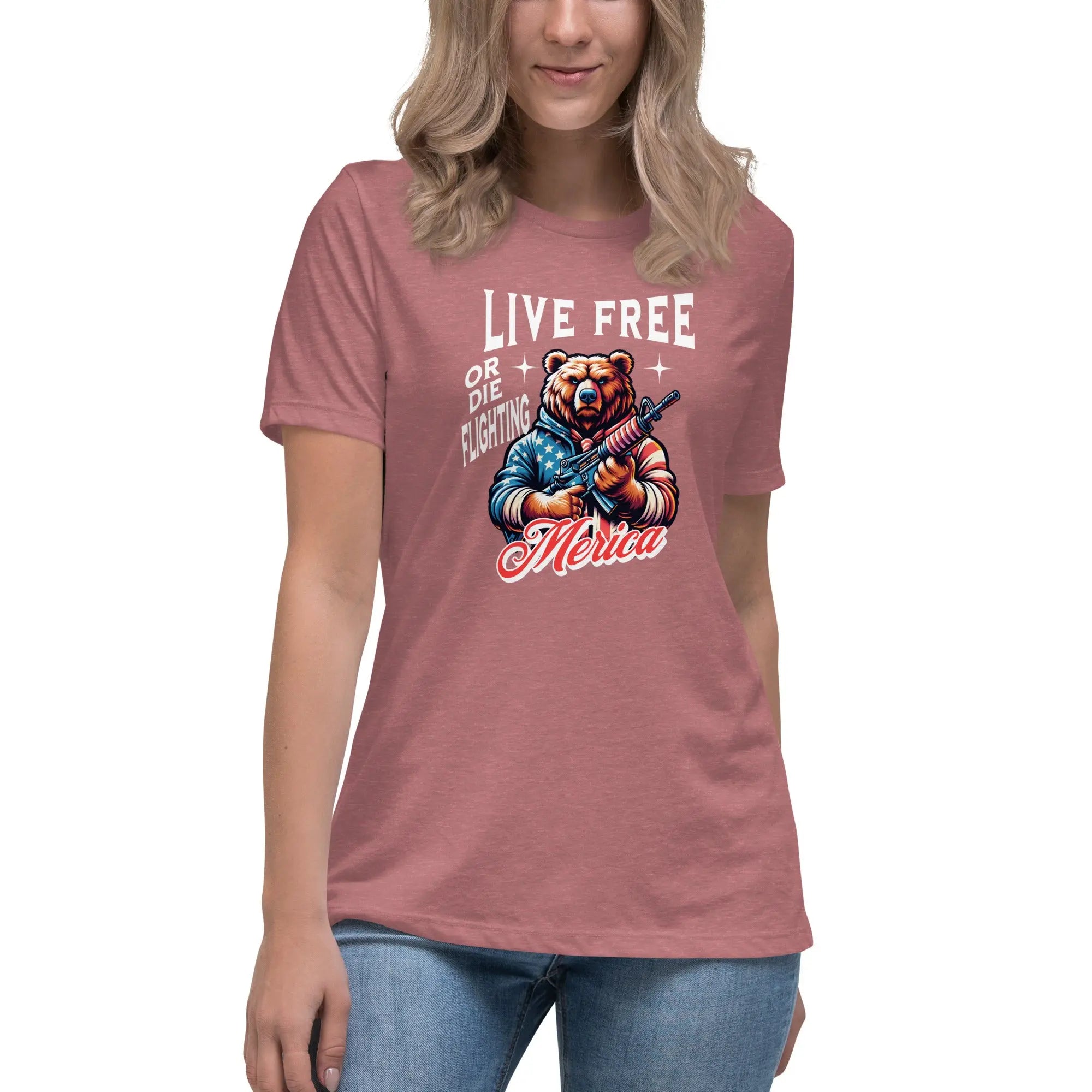 A woman wearing a heather mauve patriotic t-shirt with a bear holding a gun and "Live Free or Die Fighting" text.
