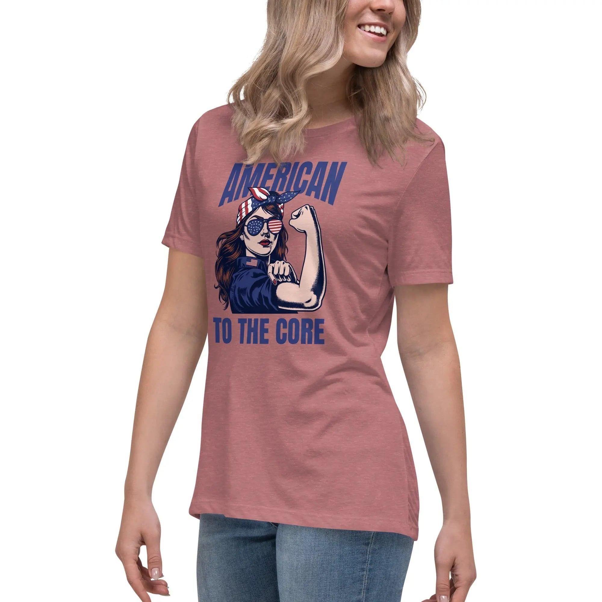 A woman wearing a heather mauve, patriotic t-shirt with a strong woman and "American To The Core" text.