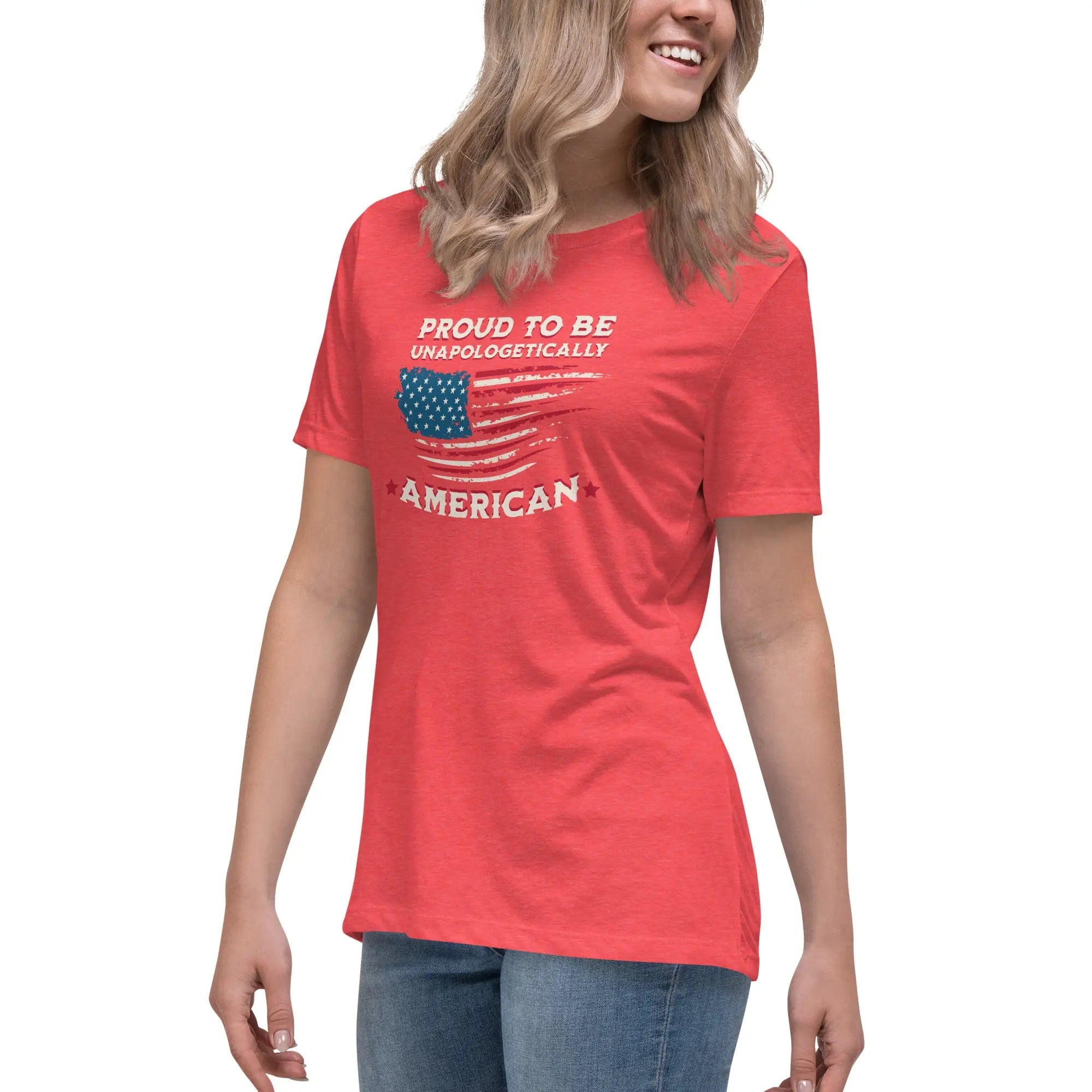 A woman wearing a heather red patriotic t-shirt with the American flag and "Proud To Be Unapologetically American" text.