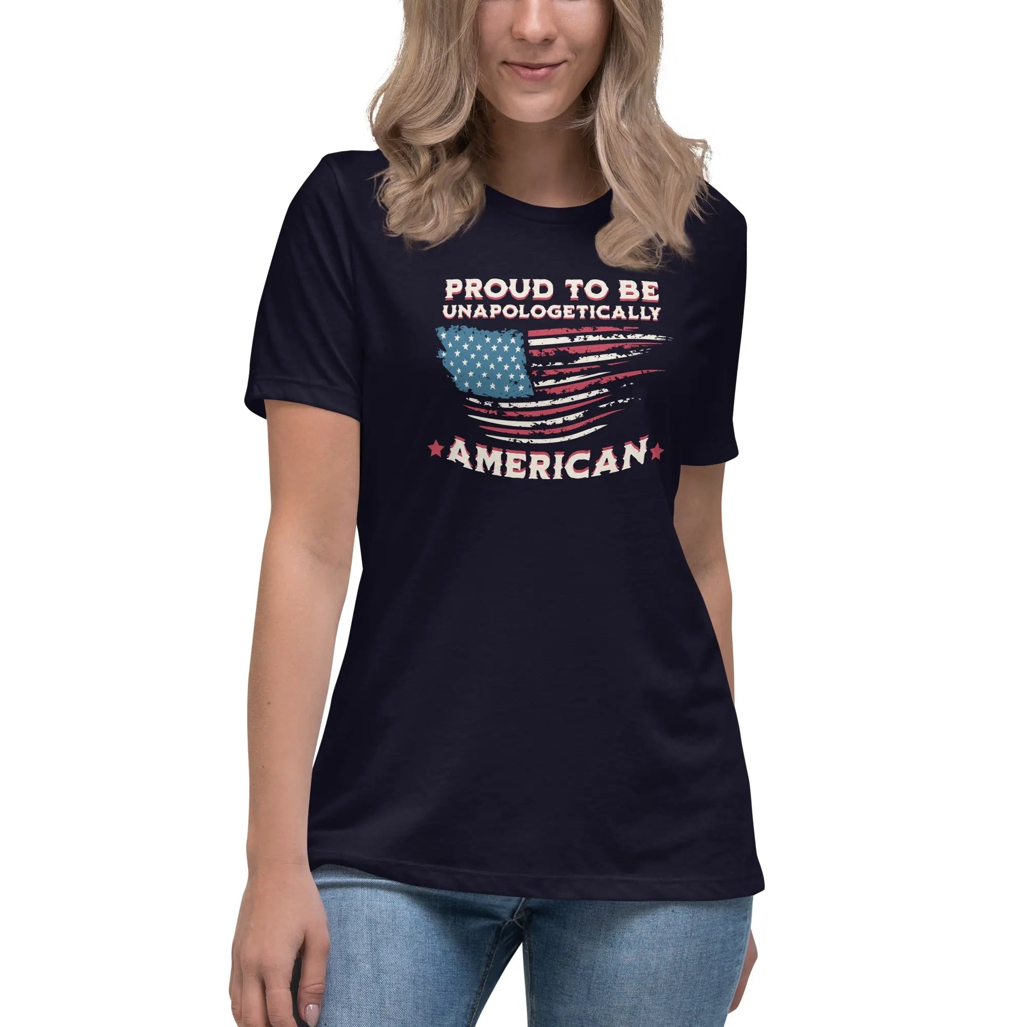 A woman wearing a navy patriotic t-shirt with the American flag and "Proud To Be Unapologetically American" text.