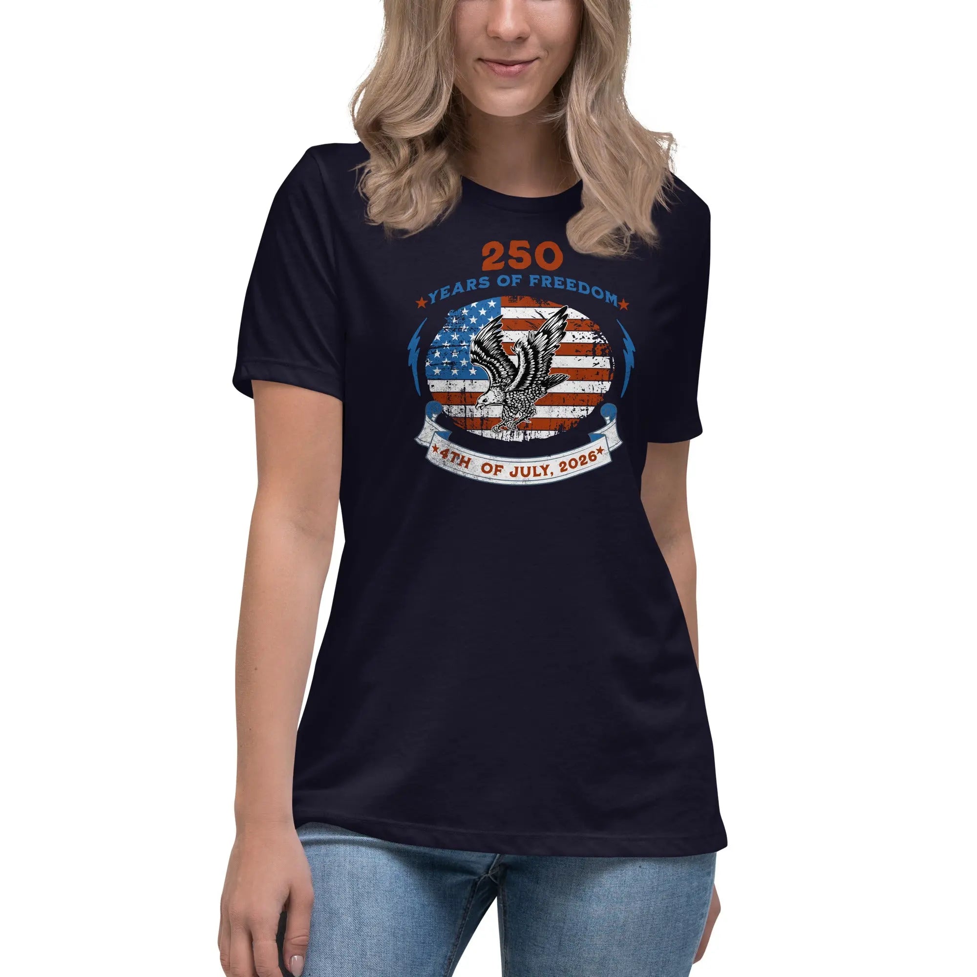 A woman wearing a navy patriotic t-shirt with the American flag with a flying eagle over it and the text "250 years of freedom 4th of July, 2026."